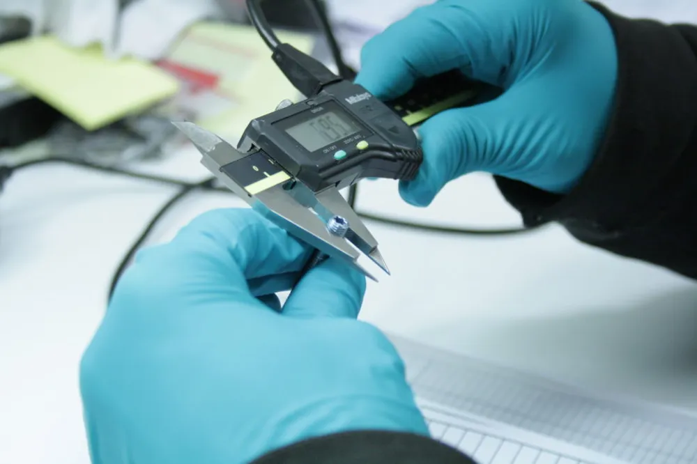 Inspection with a digital caliper, gloved hands